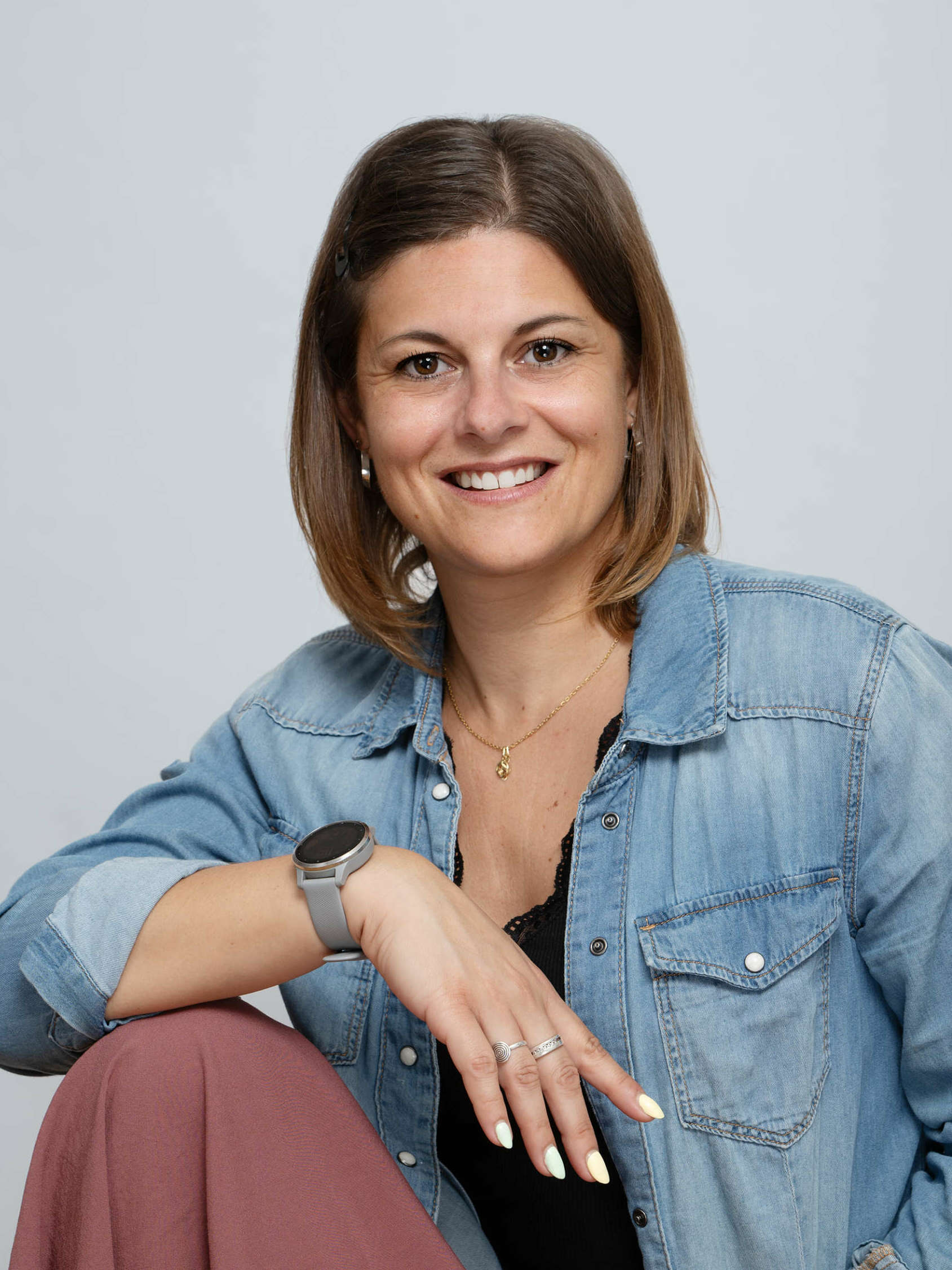 Portrait de Lise, assistante administrative indépendante, souriante et posant en tenue décontractée à Perpignan.